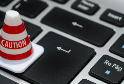 Image of a keyboard with a cone on it that has the word "caution" written on it